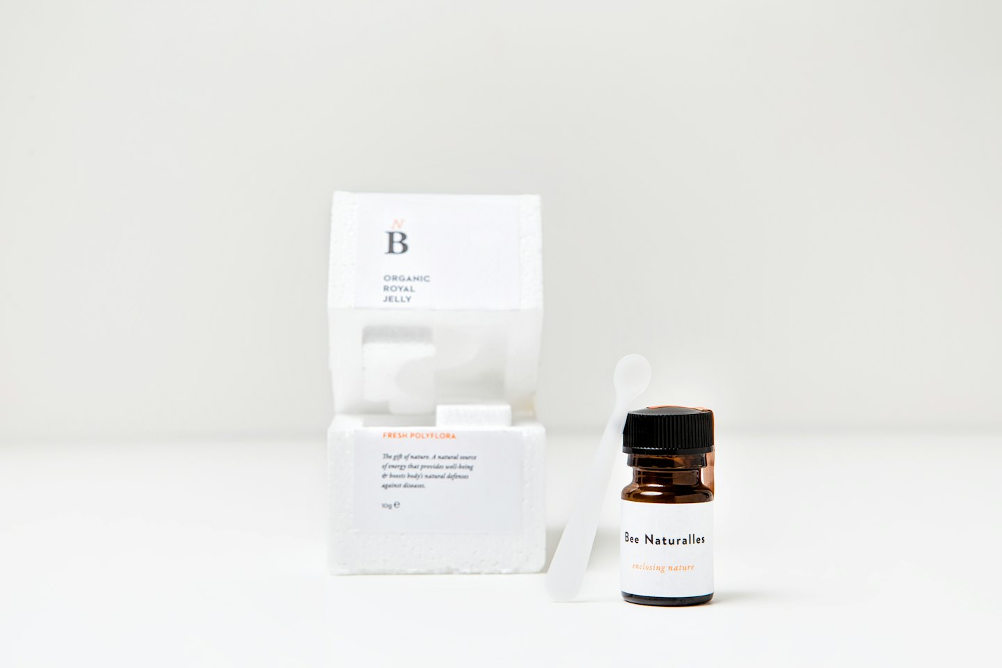 Bernsteinfarbene Flasche mit Gelée Royale, Löffel und Verpackung.